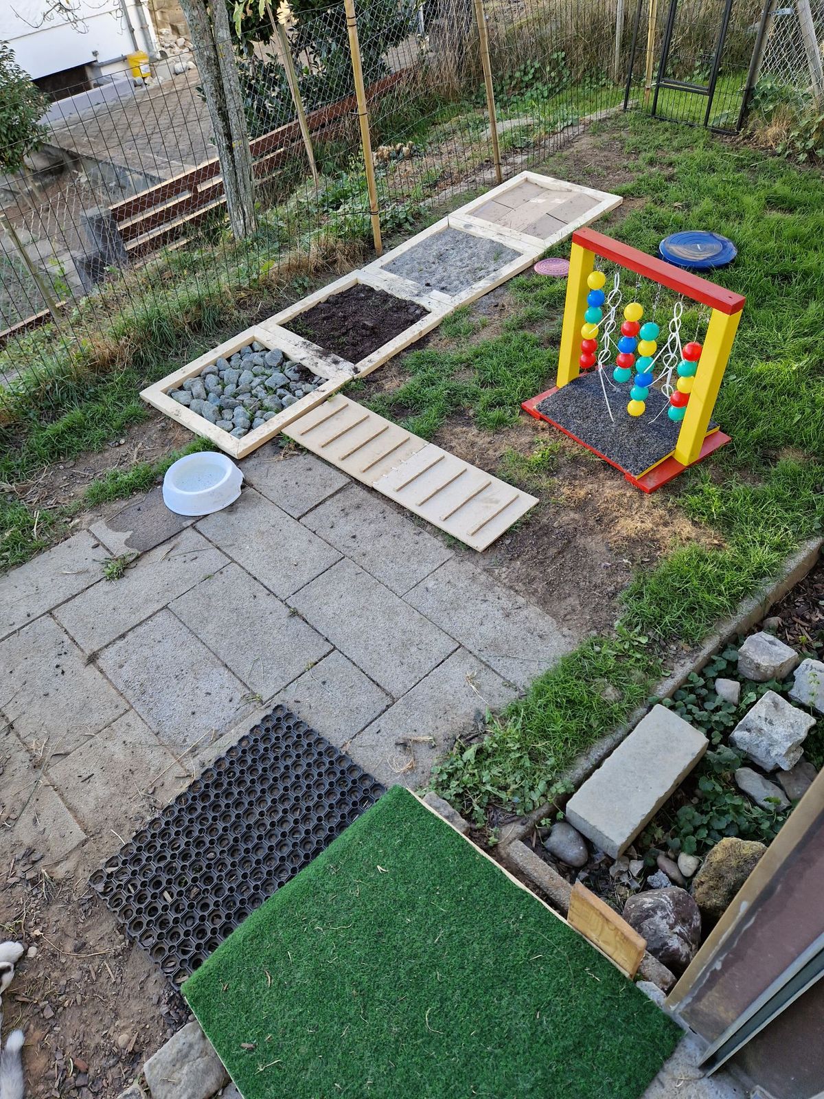 Beschäftigungsbereich im Garten mit Rampen, Buddelkiste und verschiedenen Untergründen
